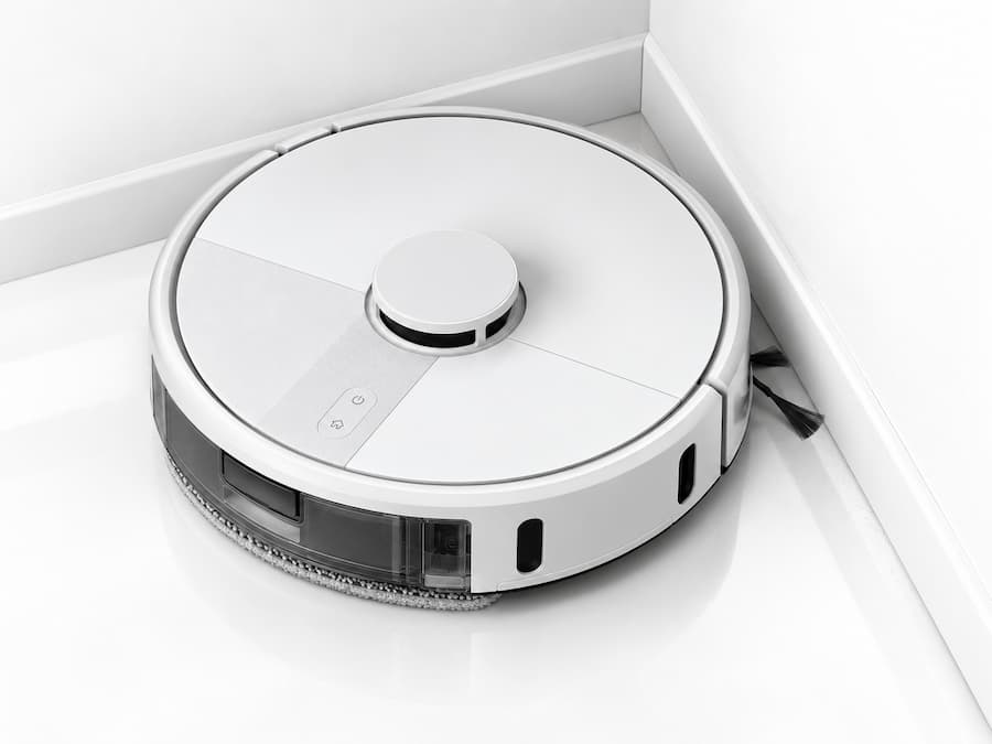 Roomba 115 Combo Blanco limpiando bordes y esquinas con su cepillo lateral